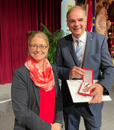 Die Bundesgeschäftsführerin der Johanniter neben Wolfgang Kastel, der das Goldene Ehrenzeichen in der Hand hält
