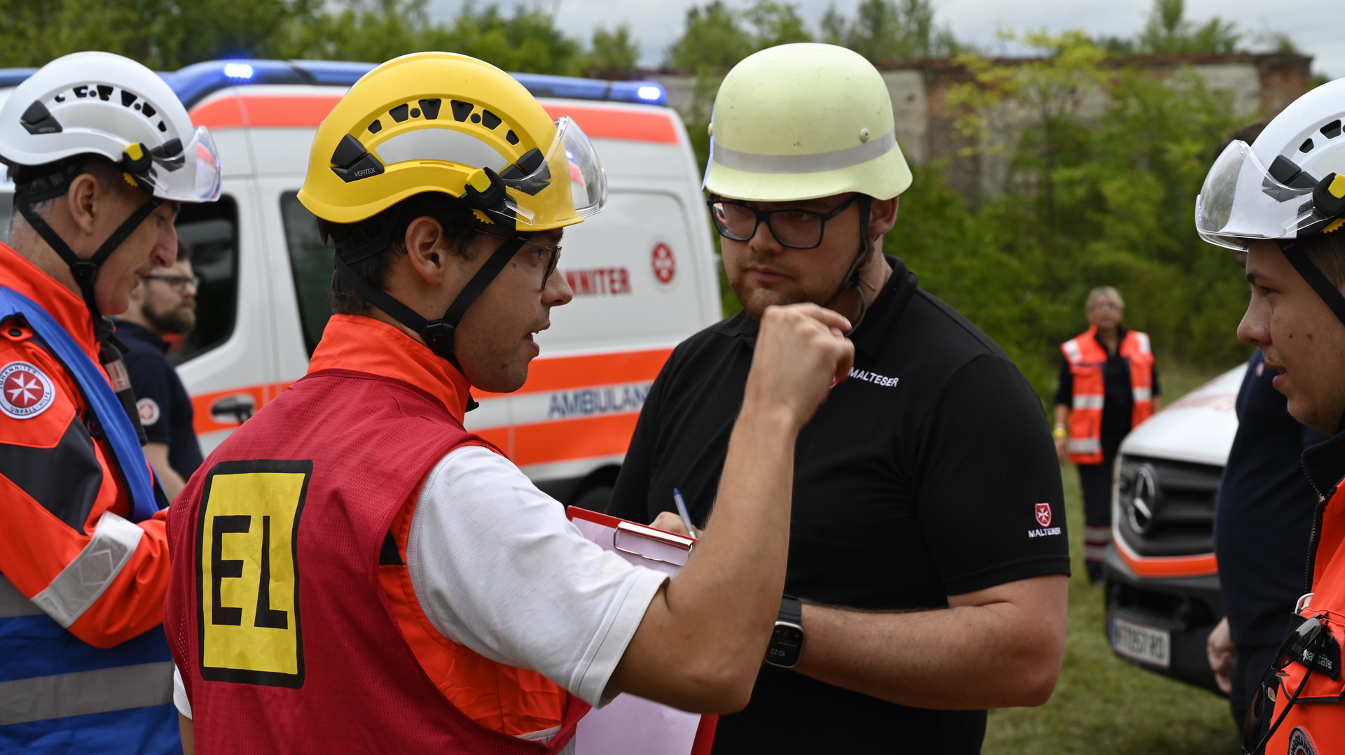 mehrere Sanitäter in Uniform besprechen sich vor dem Einsatz