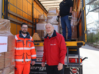 Ein Johanniter und der Bundesgeschäftsführer der Johanniter beim Beladen des LKWs mit Hilfsgütern.