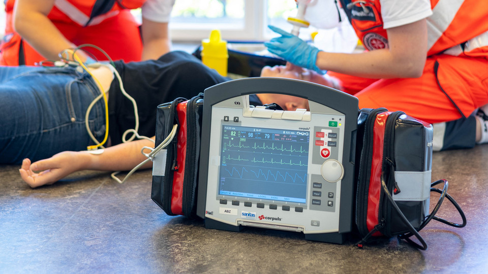 Ein Rettungssanitäter und eine Rettungssanitäterin versorgen eine Patientin mithilfe des Corpuls-Geräts.