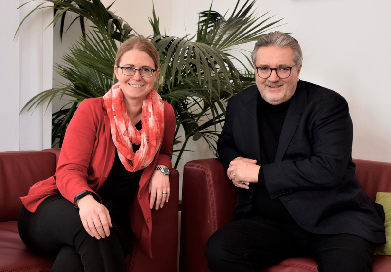 zwei Personen sitzen auf einem Sofa, sie lächeln in die Kamera, links Bundesgeschäftsführerin der Johanniter Petra Grell-Kunzinger und rechts Stadtrat Peter Hacker