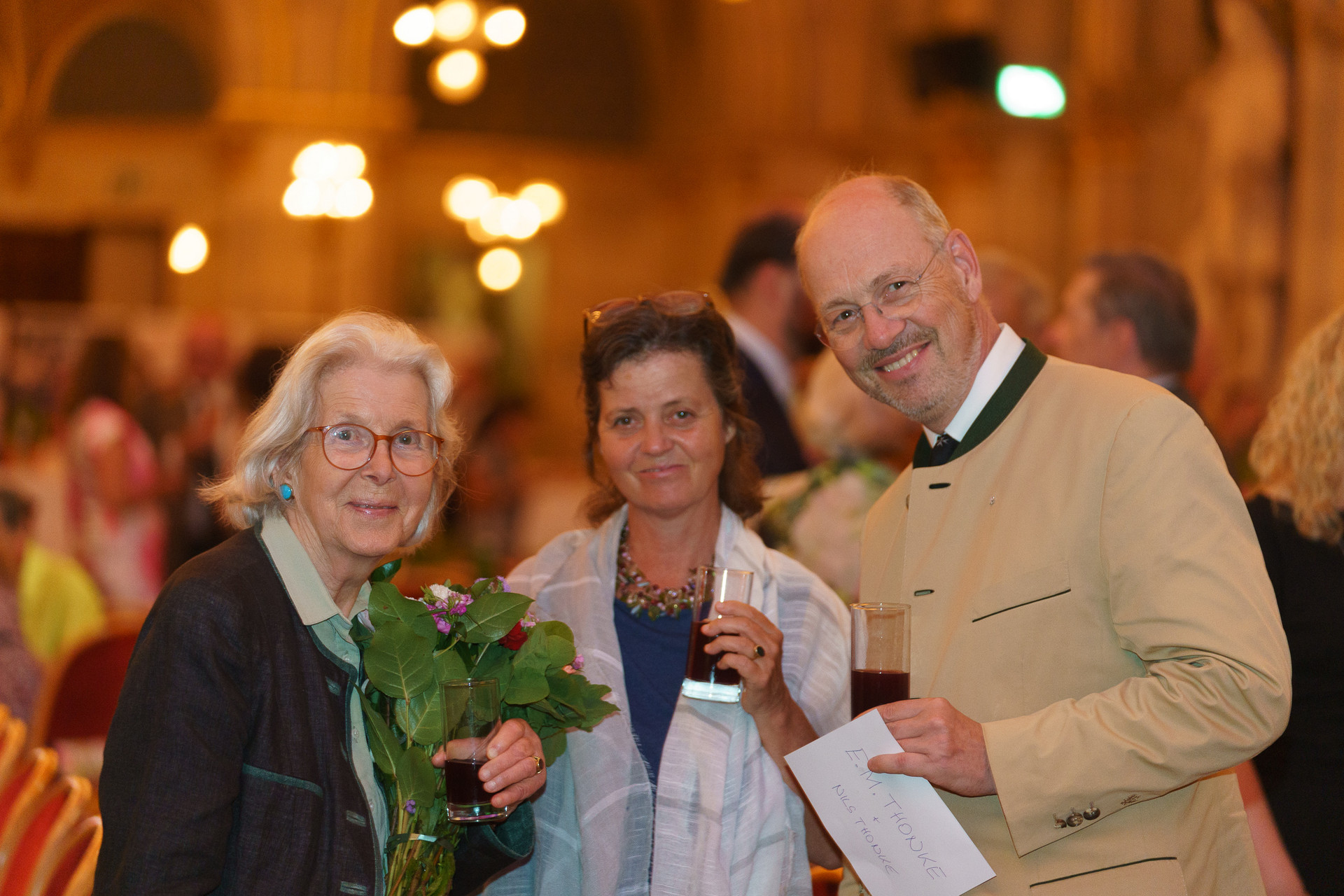 3 Personen lächeln in die Kamera