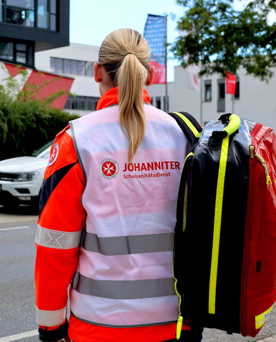 Ein Schulsani der Johanniter mit einem Notfall-Rucksack