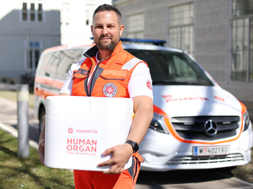 Ein Johanniter hält eine Transportbox mit einem Spenderorgan in der Hand.