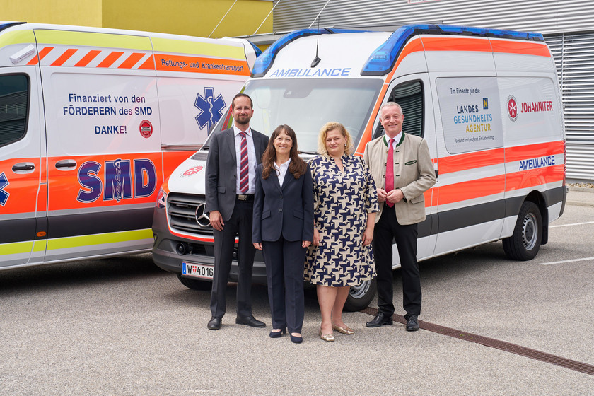 Vertreter:innen von SMD, Johanniter und NÖ LGA vor den Einsatzautos der Johanniter und des SMDs.