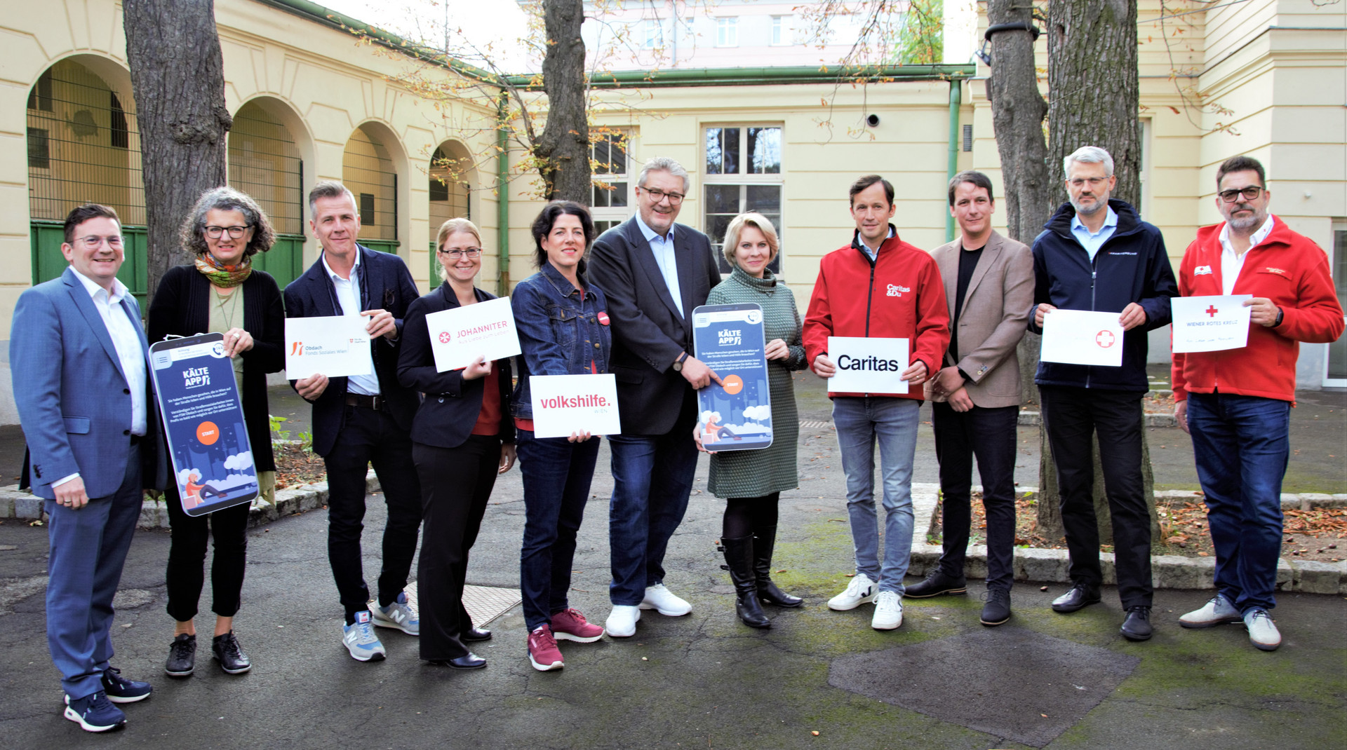 Vertreter:innen aller Partnerorganisationen des Winterpakets halten je ein Schild mit dem Logo ihrer Organisation hoch.