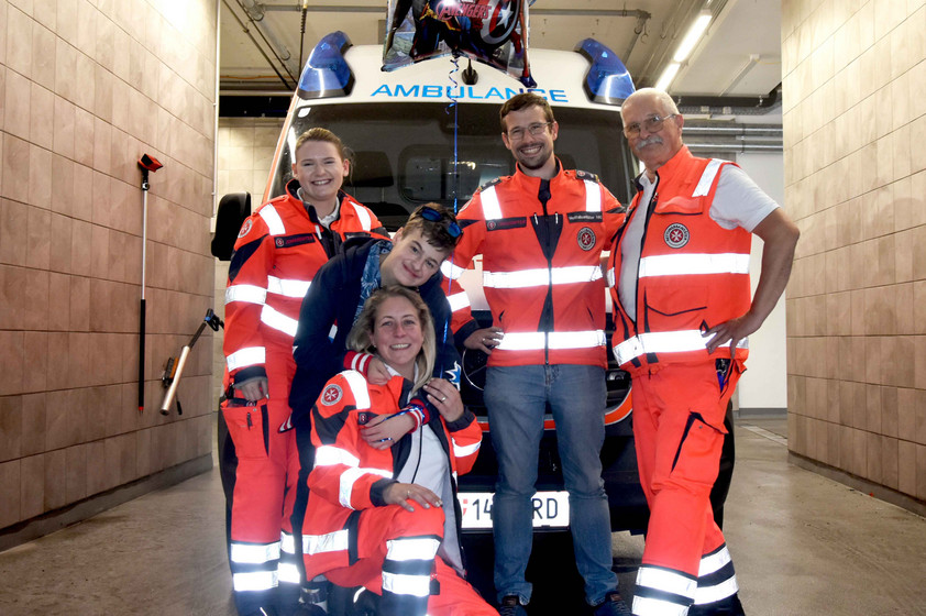 Die Johanniter gemeinsam mit einem Jungen vor dem Johanniter-Auto.