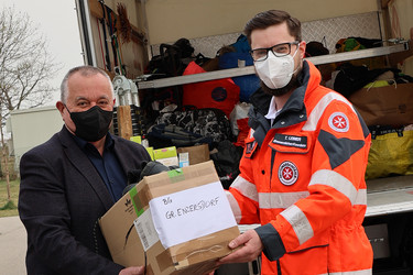 Ein Johanniter und ein Vertreter der Schule BGRG Groß-Enzersdorf, die Spenden für die Ukraine gesammelt haben.