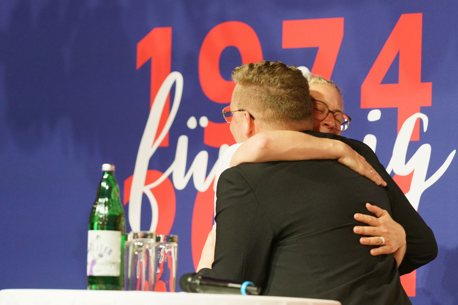 2 Personen umarmen sich auf der Bühne