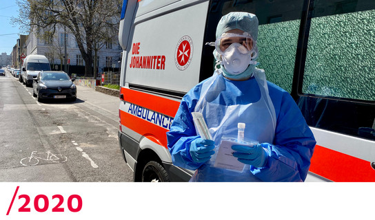 2020: Ein Covid-Tester in Schutzbekleidung vor einem Johanniter-Auto