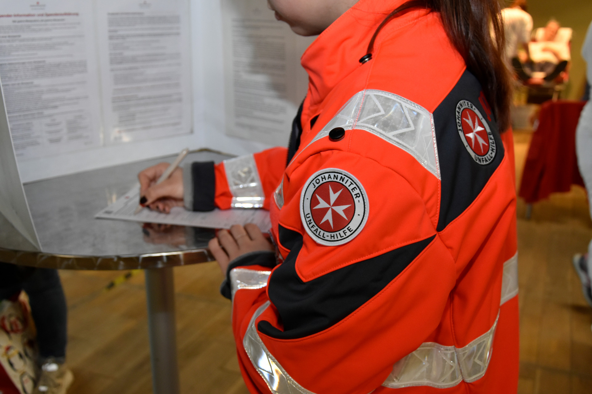 Eine Johanniterin füllt das Formular zum Blutspenden aus.