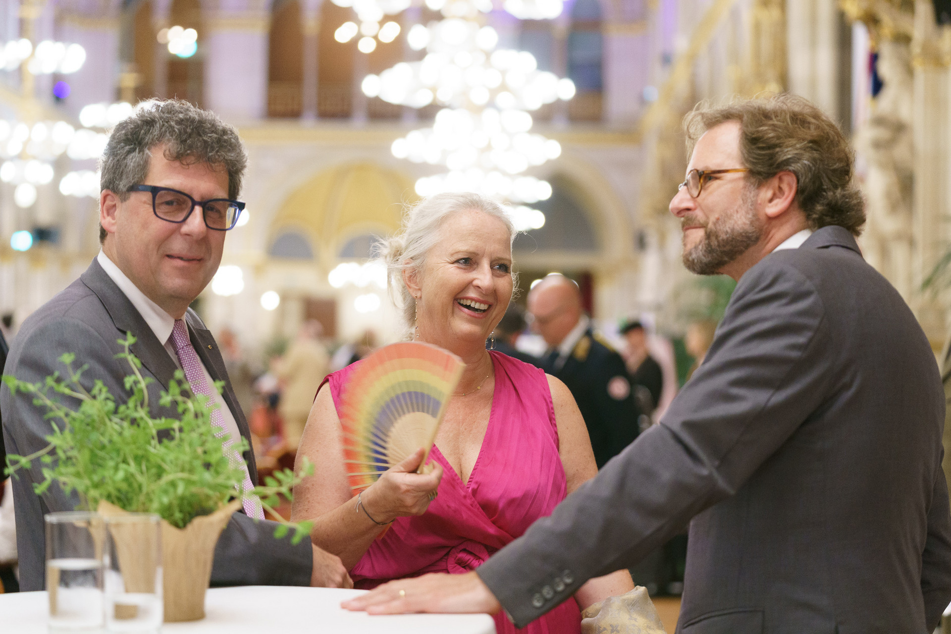 3 Personen stehen um einen Rundentisch
