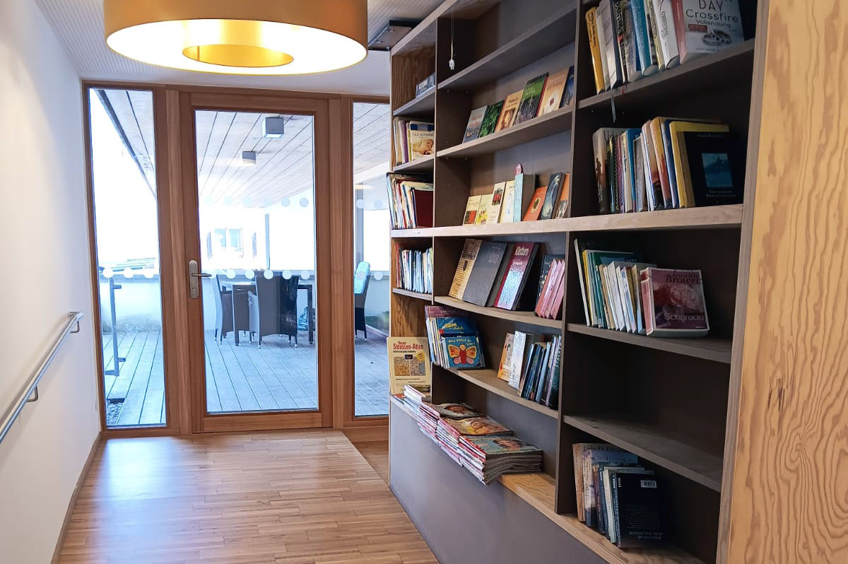 In der Wohnung ist ein großes Bücherregal am Weg zur Terrasse.