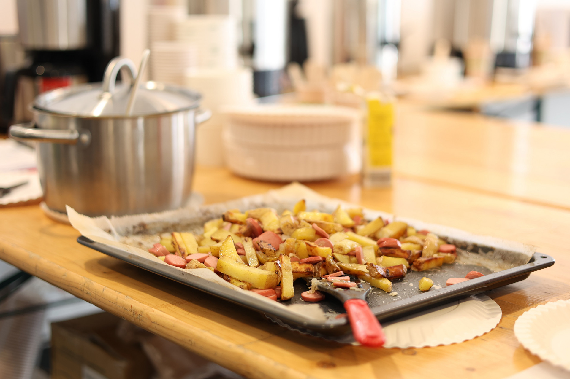 Geschnittene Erdäpfel und Wurst auf einem Backblech