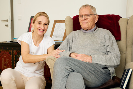 Eine Betreuerin sitzt neben einem Bewohner.
