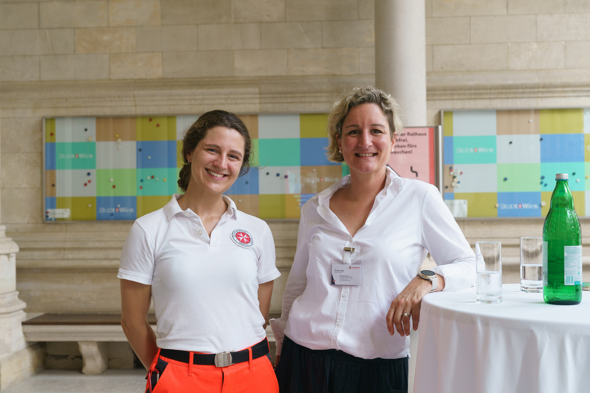 1 Rettungssanitäterin und eine Dame werden lachend fotografiert