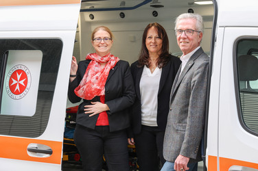Bundesgeschäftsführerin Petra Grell-Kunzinger, Geschäftsführerin Wien-NÖ Karin Zeiler-Fidler und Johanniter Präsident Johannes Bucher stehen in einem Krankenwagen.