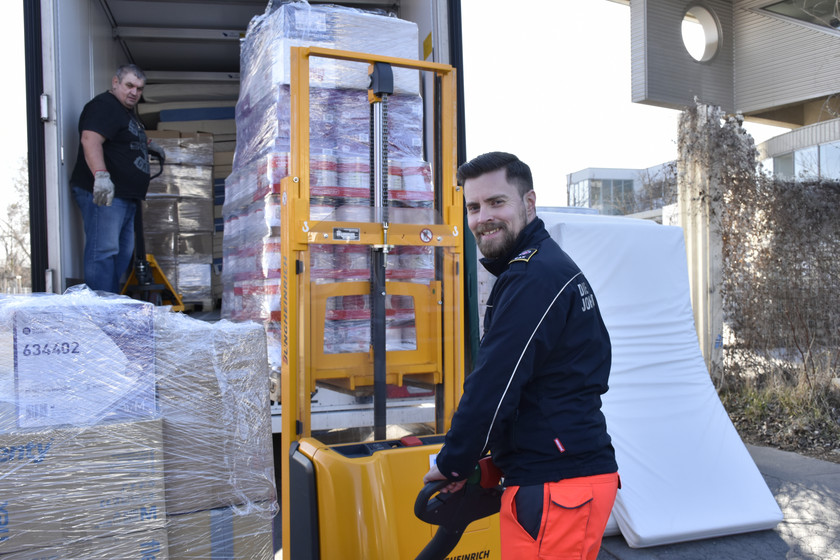 Ein Johanniter hilft beim Beladen eines LKWs mit Hilfsgütern.