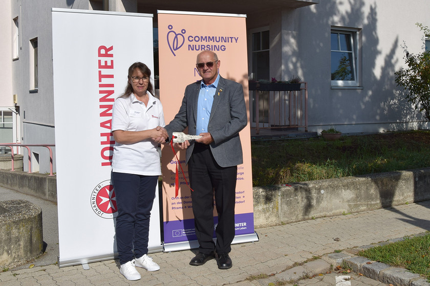 Bei der Eröffnung gibt der Bürgermeister der Community Nurse symbolisch einen extra-großen Schlüssel zum neuen Büro.