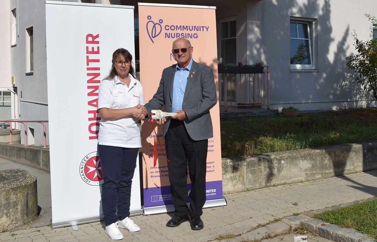 Bei der Eröffnung gibt der Bürgermeister der Community Nurse symbolisch einen extra-großen Schlüssel zum neuen Büro.