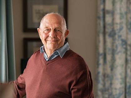 Ein älterer Mann lächelt in die Kamera.