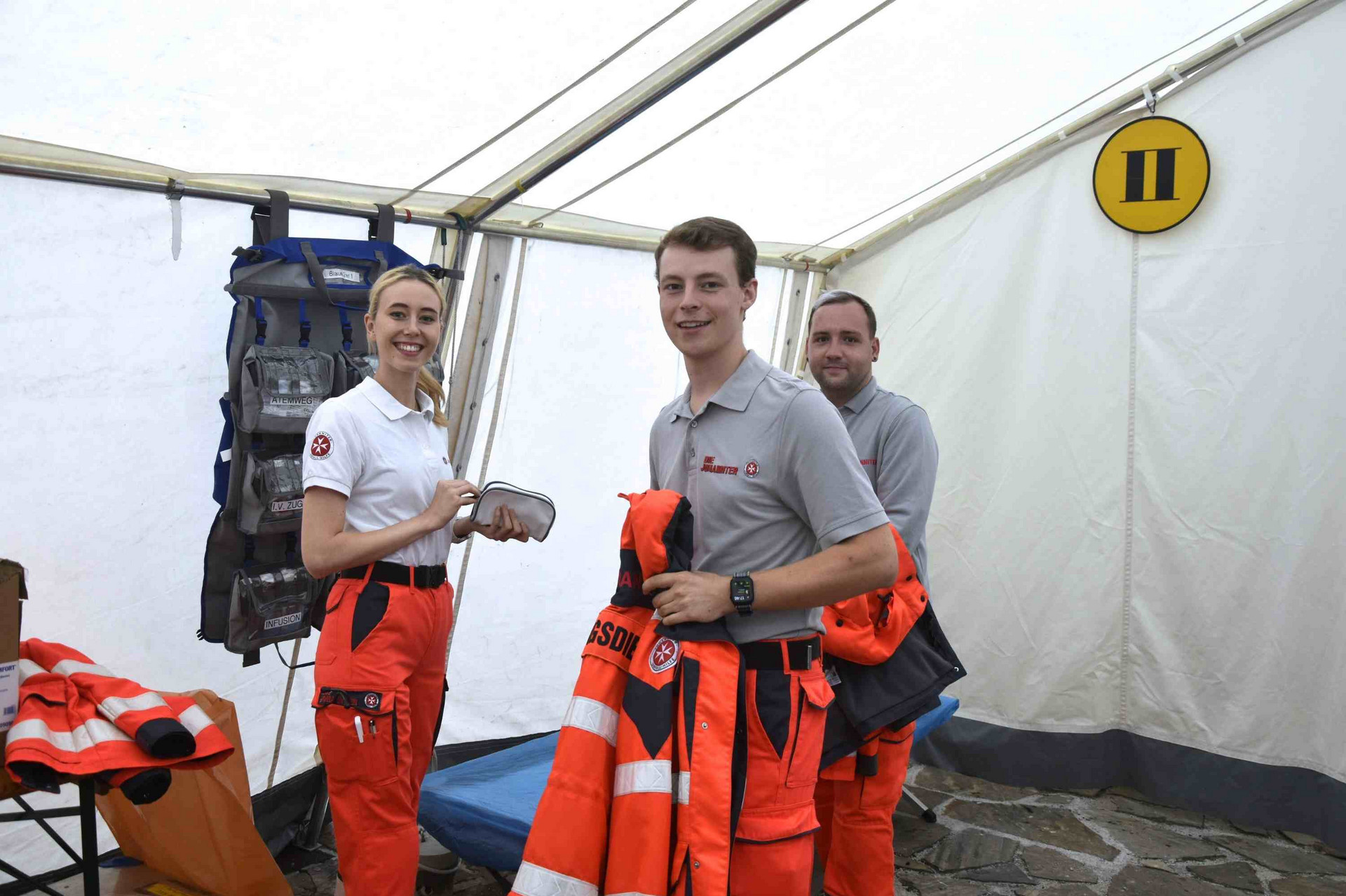 Drei Sanitäter:innen im Sanitätszelt, wo potenzielle Patient:innen versorgt werden.