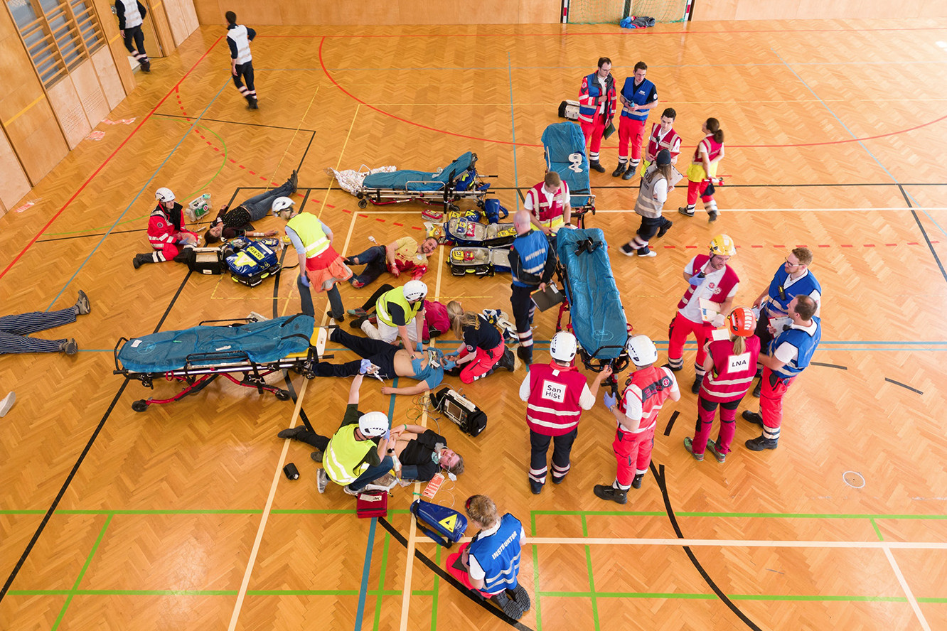 Ein Blick von oben auf die Übung, wo in einem Turnsaal verletzte Personen versorgt werden.