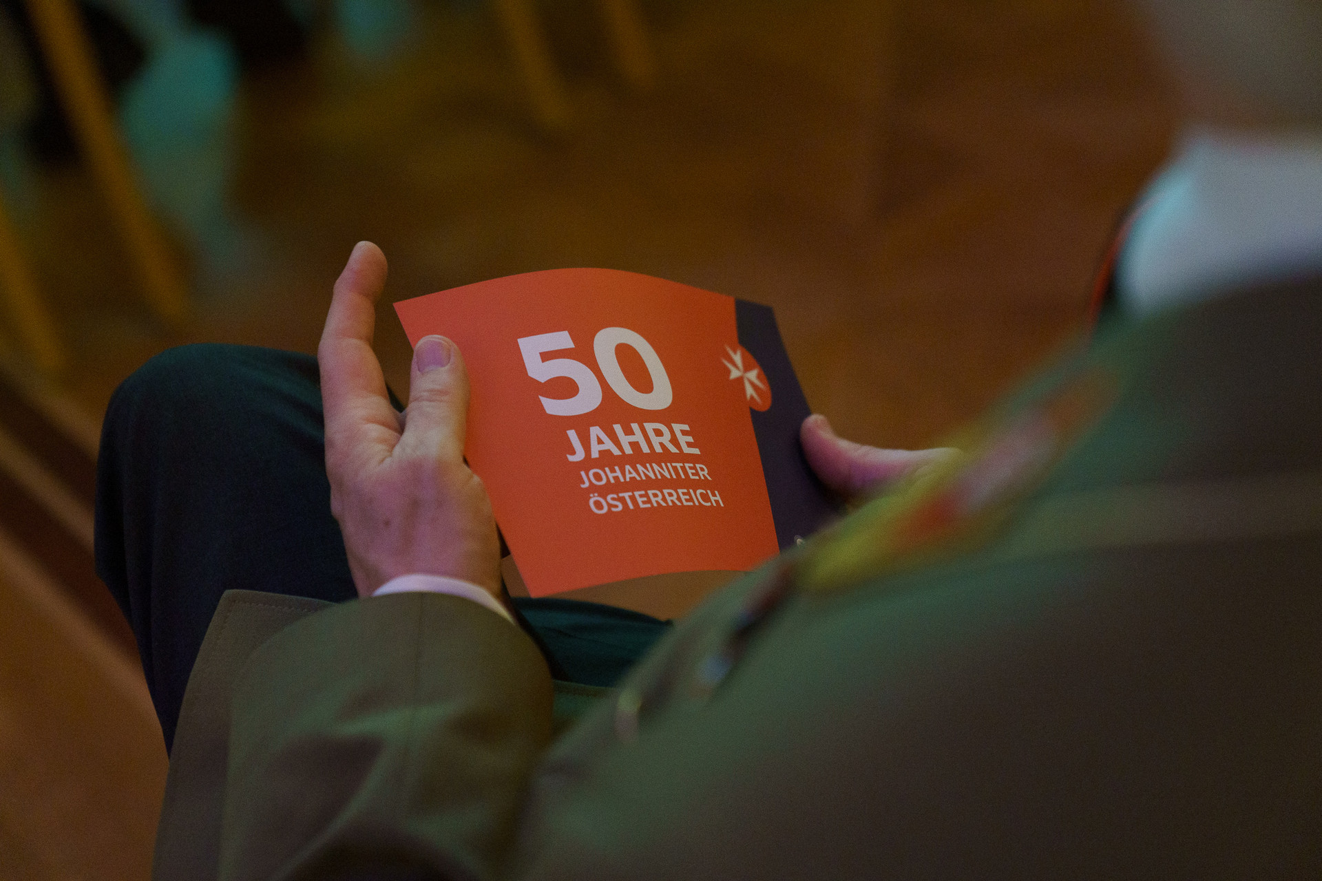 Jemand hält eim 50 Jahre Johanniter Prospekt in der Hand