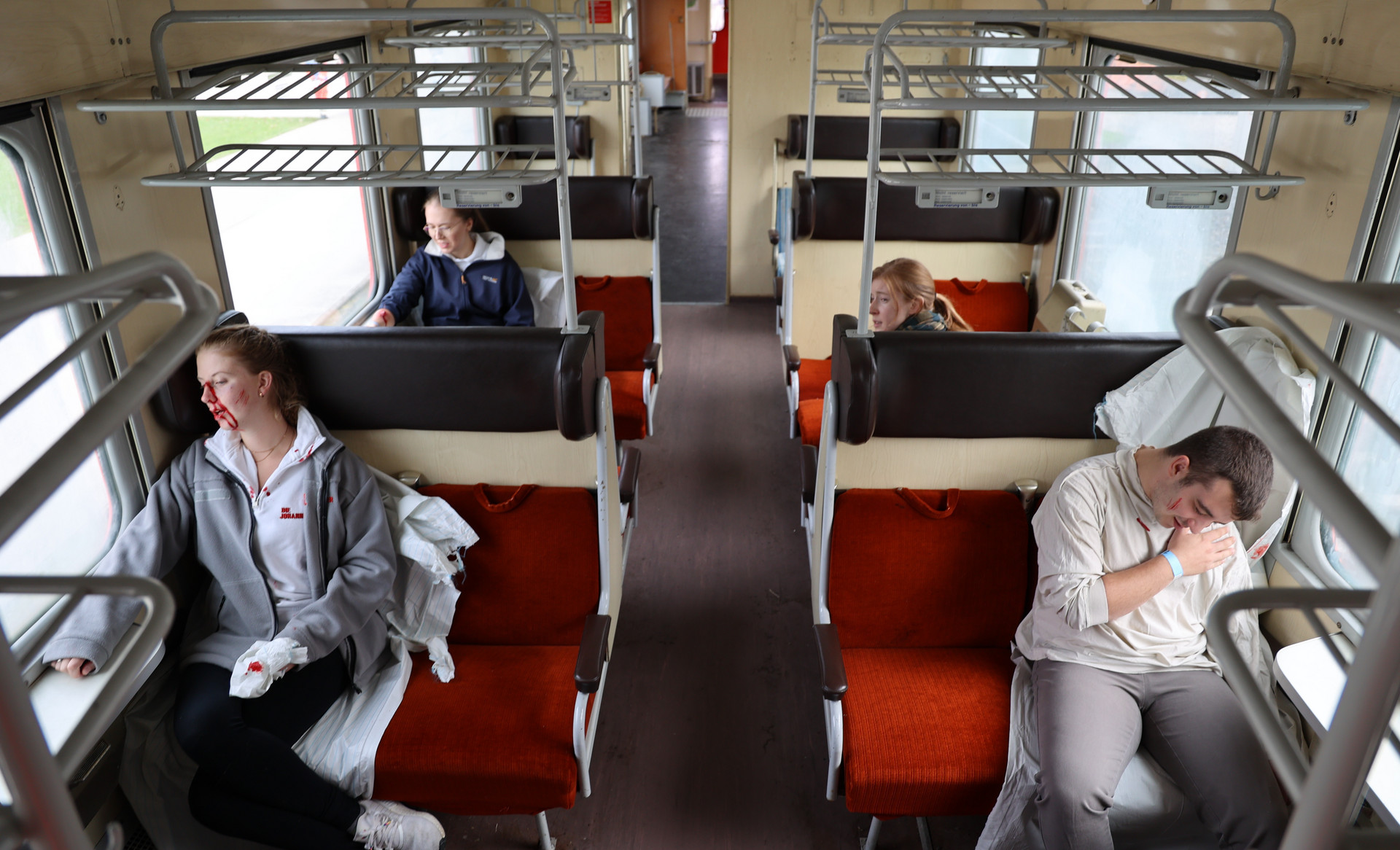 In einem Zug sitzen vier verletzte Personen.