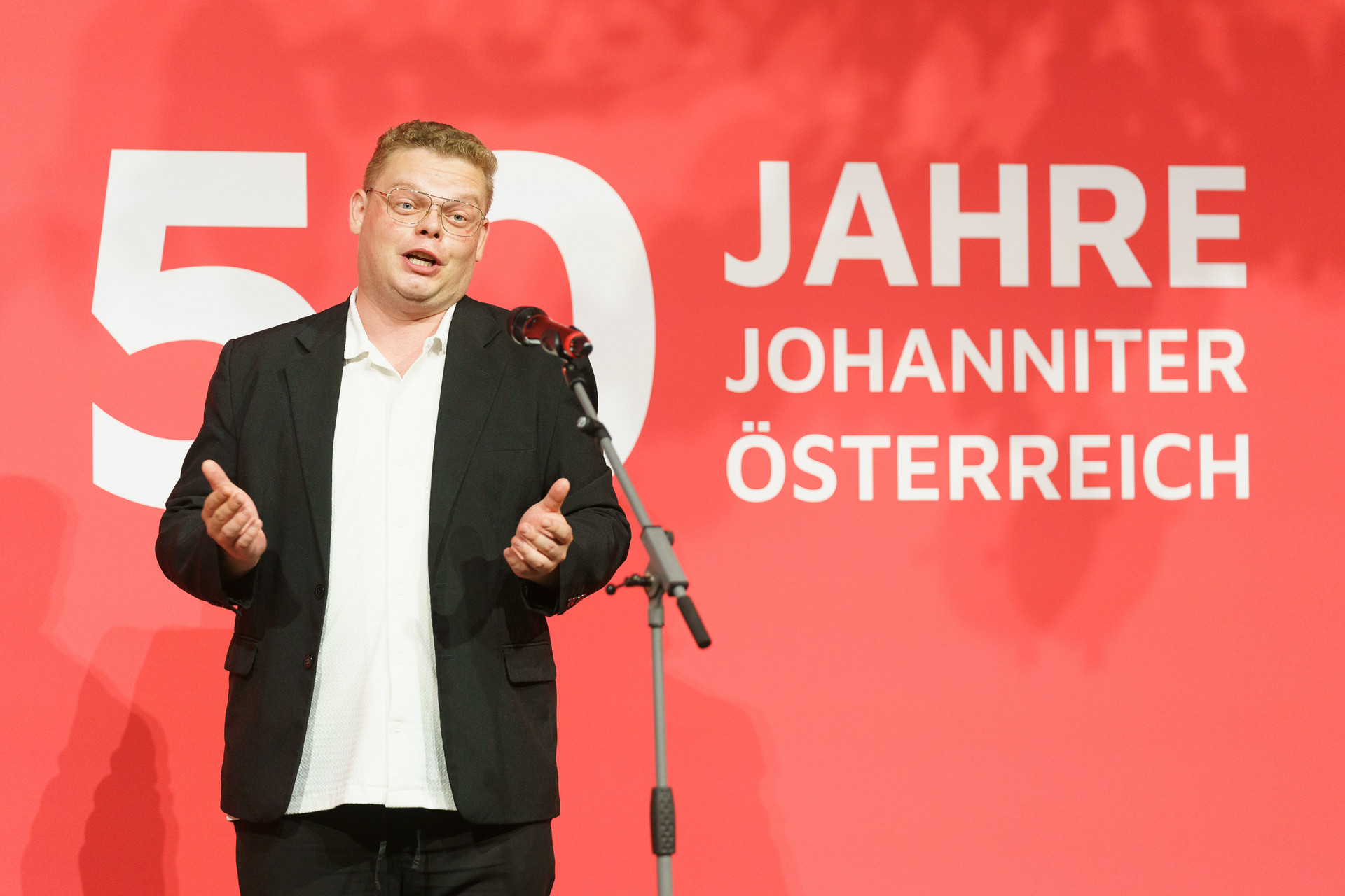 Person steht auf der Bühne und trägt etwas vor