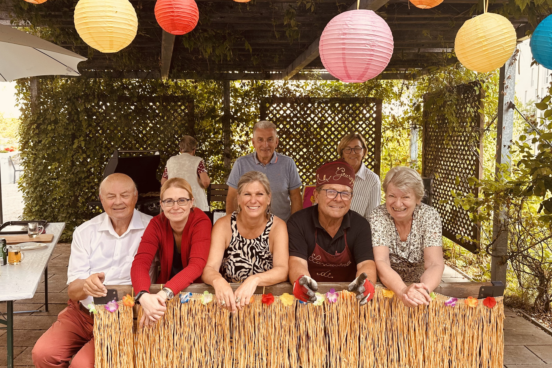 Die Helfer:innen beim Sommerfest in der Residenz lächeln in die Kamera.