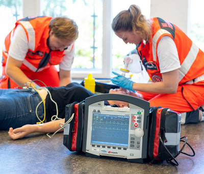 Ein Rettungssanitäter und eine Rettungssanitäterin versorgen eine Patientin mithilfe des Corpuls-Geräts.