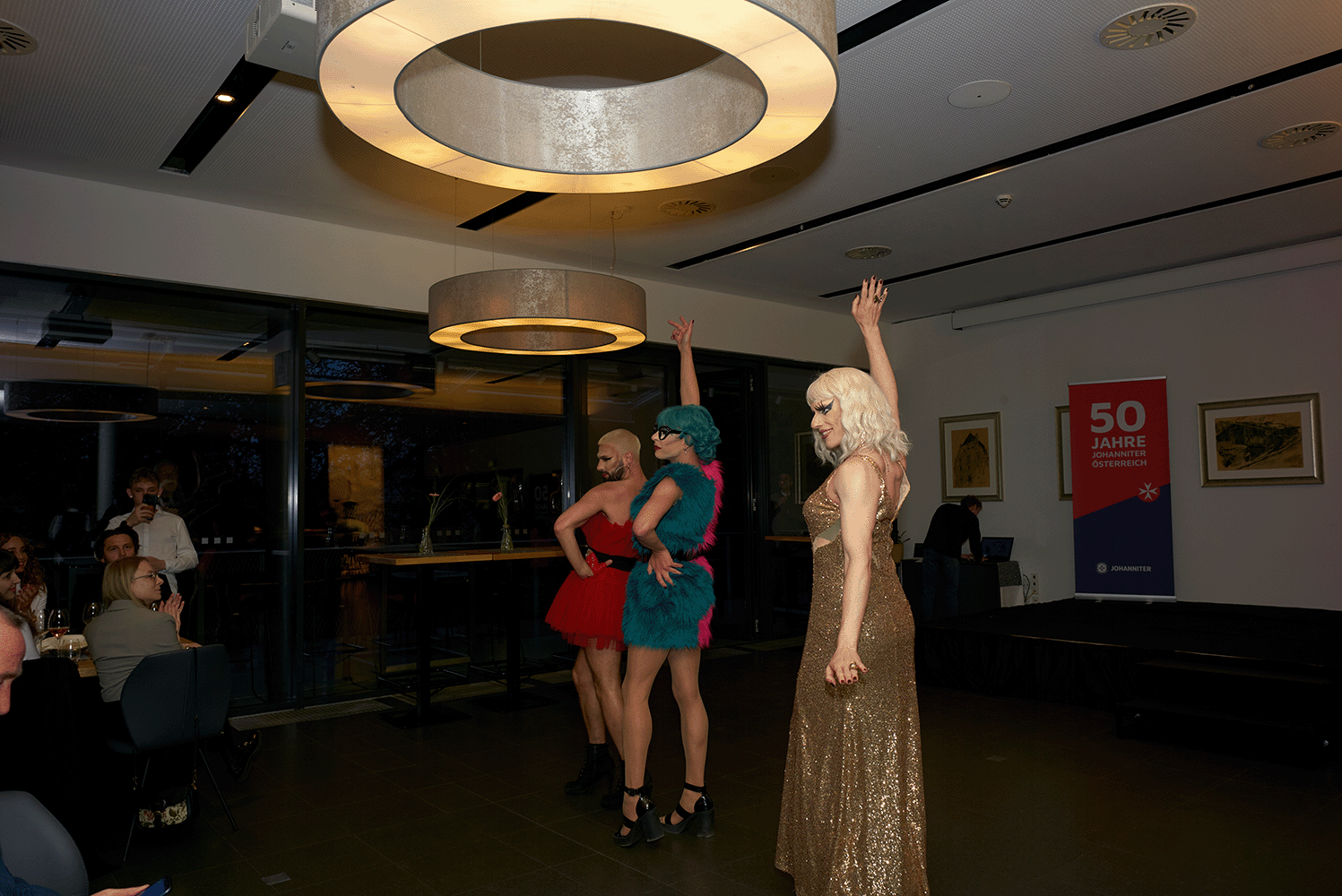 Dragqueens stehen auf der Bühne und tanzen