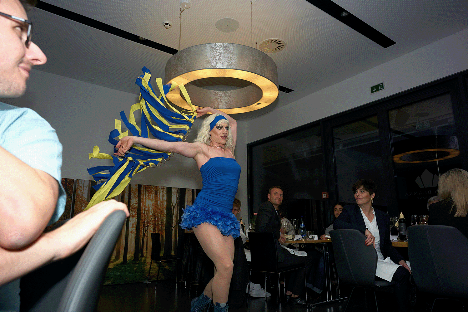 Dragqueen tanzt und Menschen schauen zu