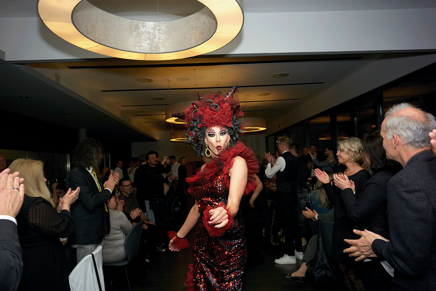 Dragqueen tanzt zwischen den Tischen und die Menschen klatschen