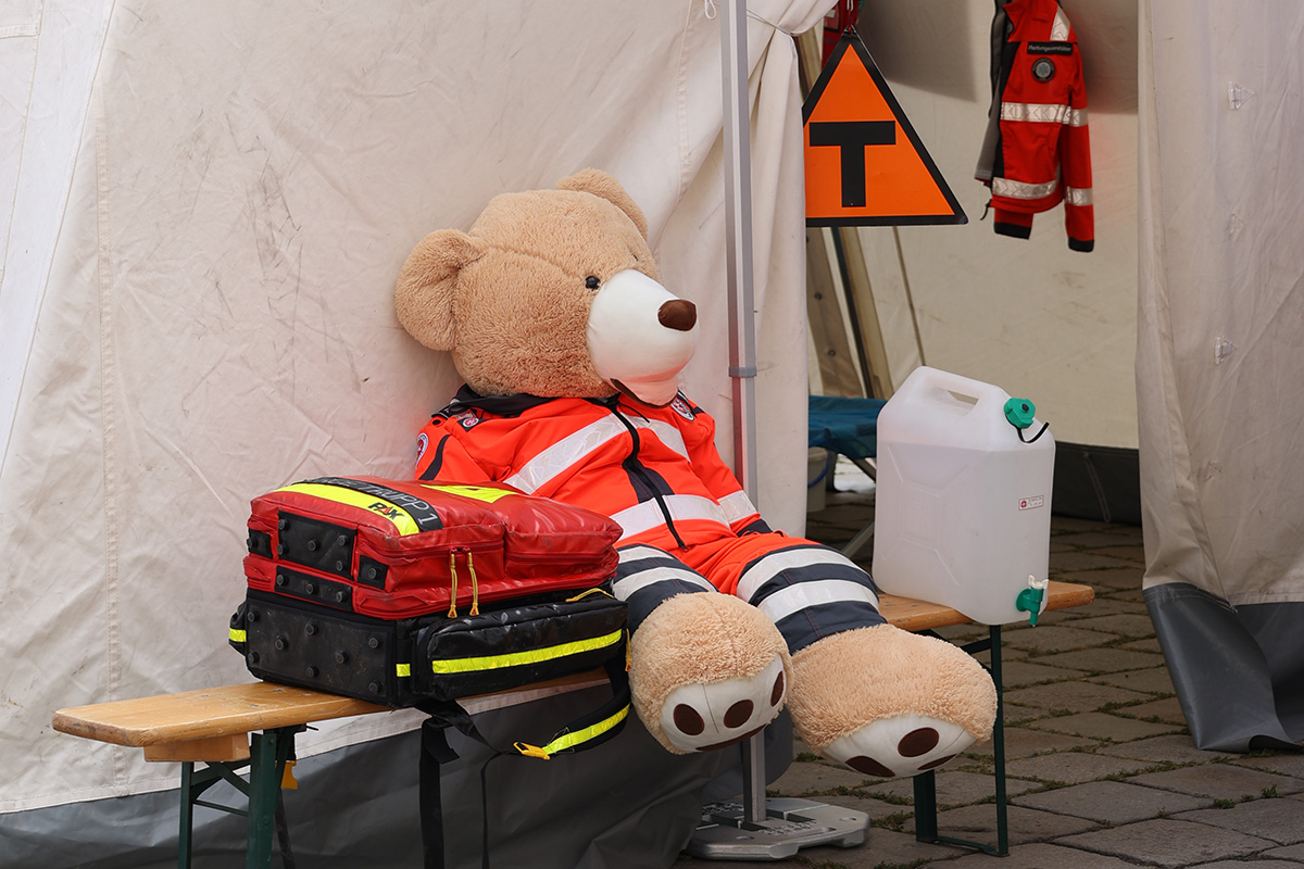 Einsatzrucksack und ein Bär der die Johanniter Einsatzjacke trägt