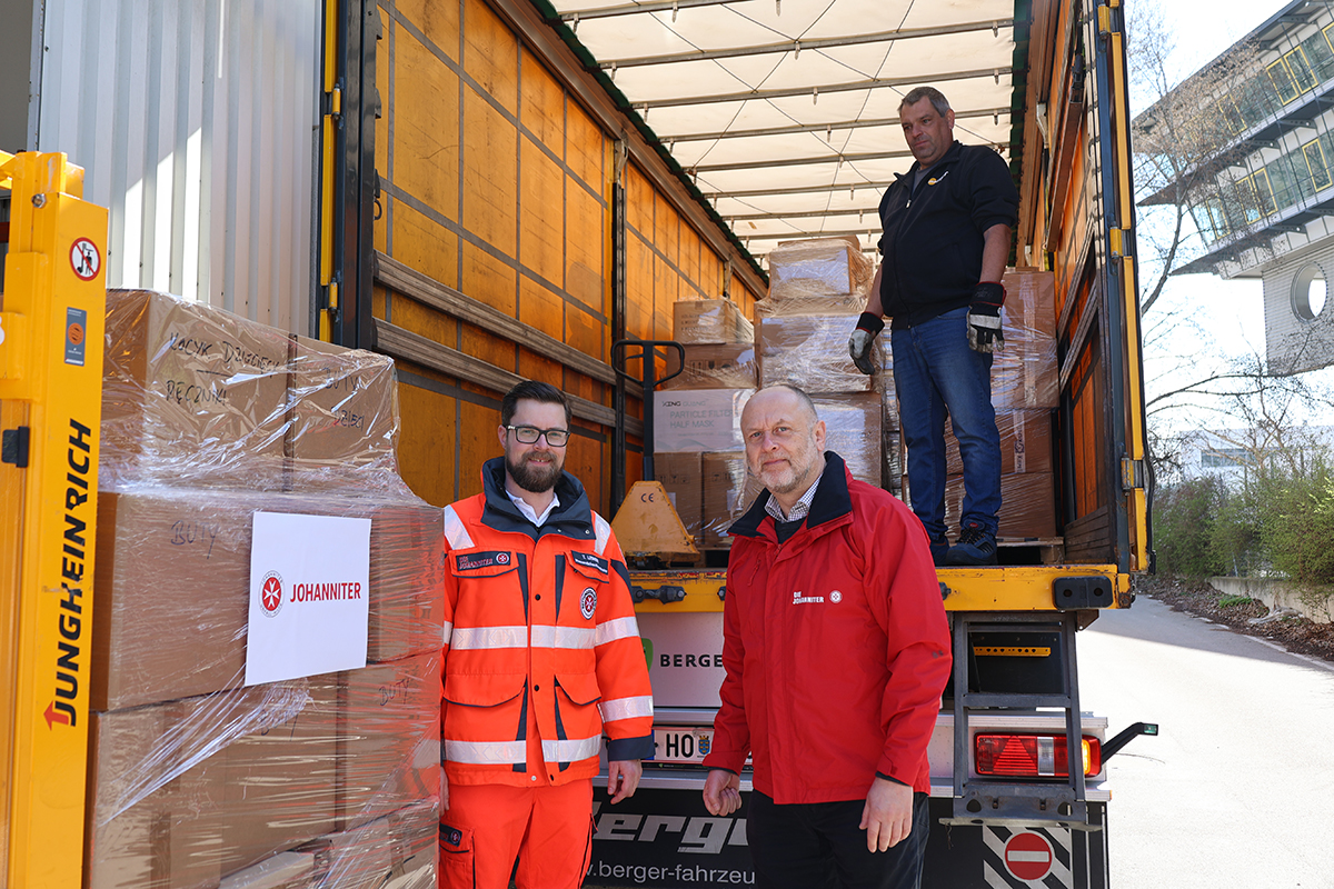 Ein Johanniter und der Bundesgeschäftsführer der Johanniter beim Beladen des LKWs mit Hilfsgütern.