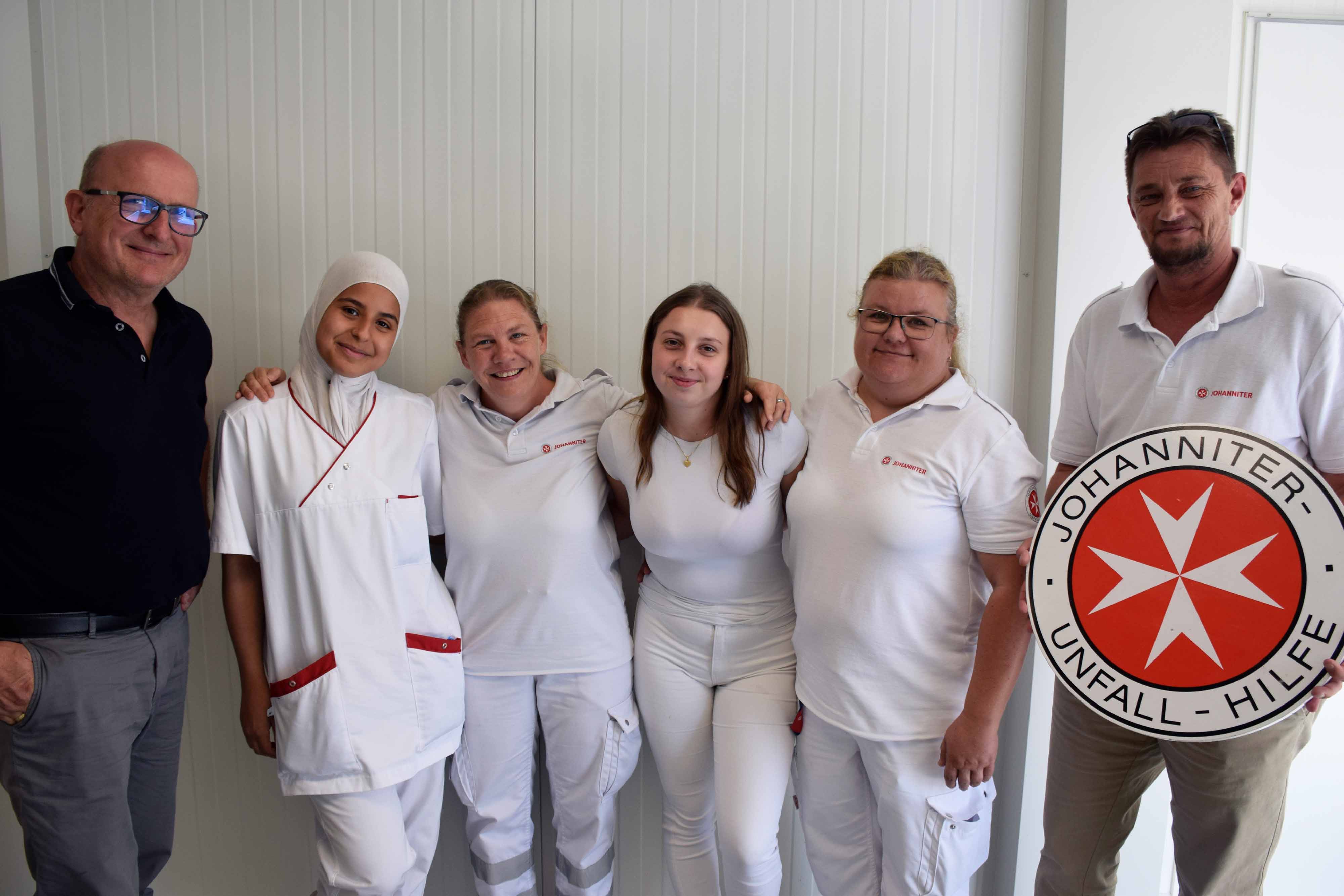 Die vier Teilnehmerinnen des Pflegeaustauschs gemeinsam mit 2 österreichischen Johannitern lächeln in die Kamera.