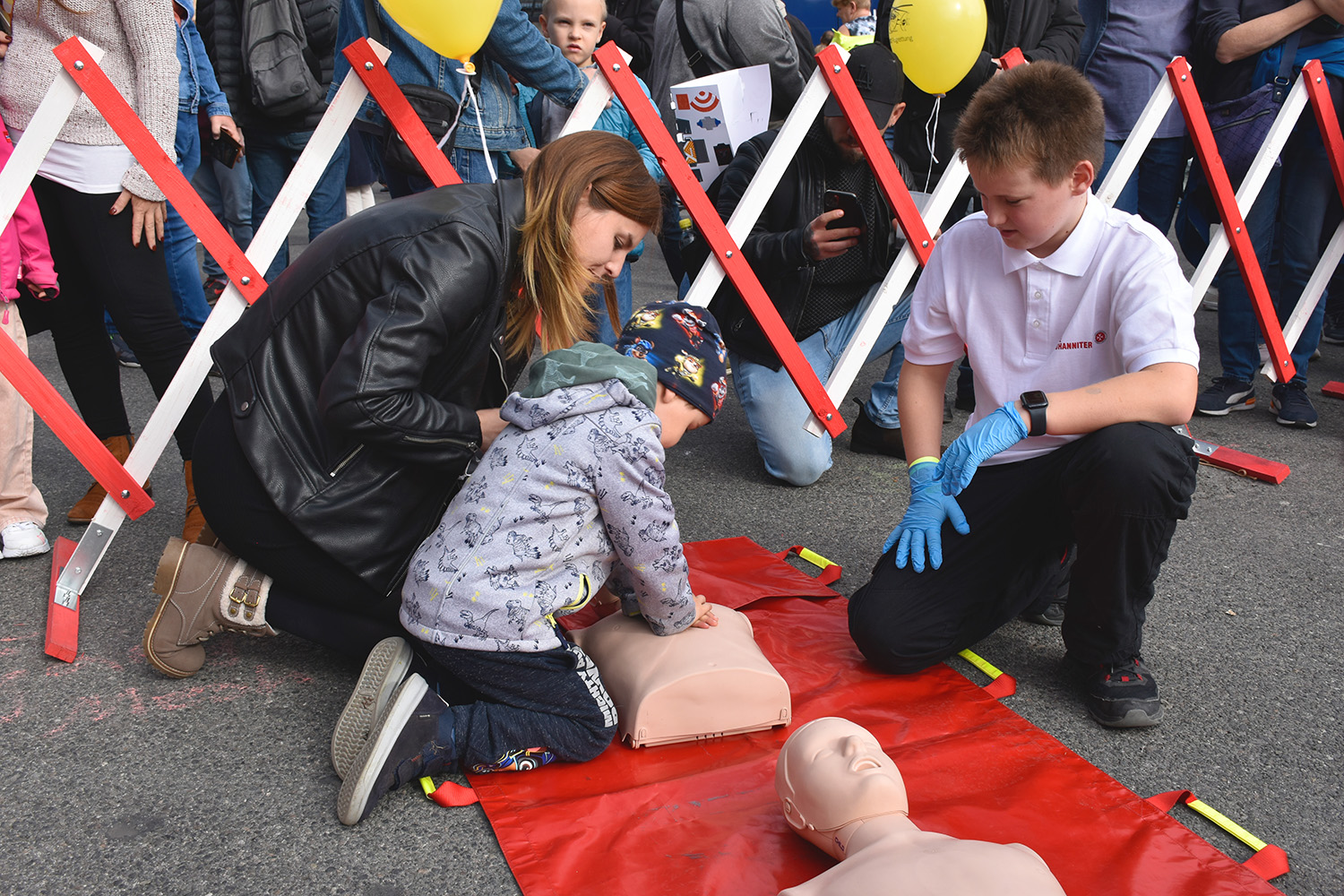 Ein Nachwuchs-Johanniter zeigt einem kleinen Jungen die Herzdruck-Massage.