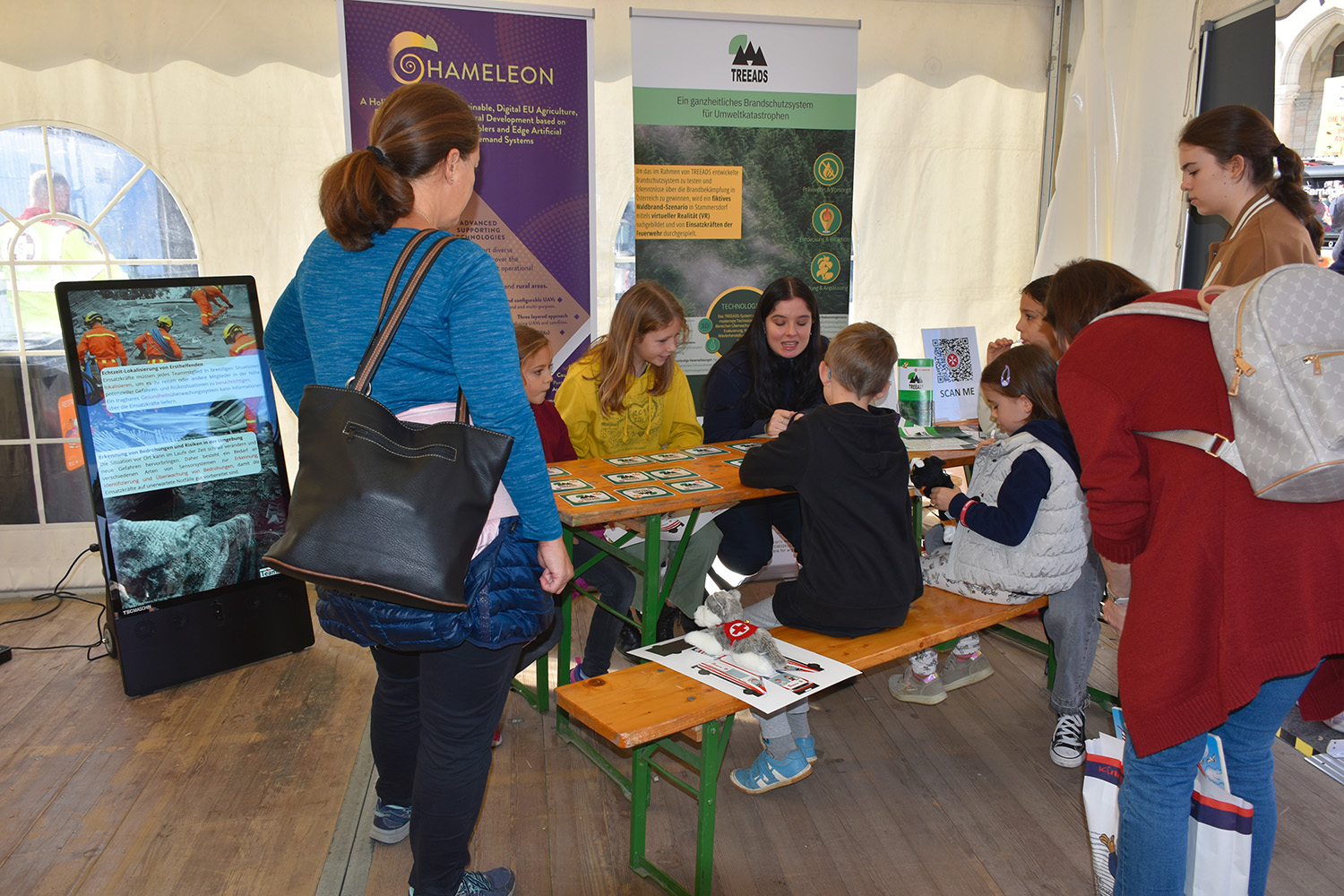 Kinder spielen Memory mit einer Johanniterin zum Thema Forschung.