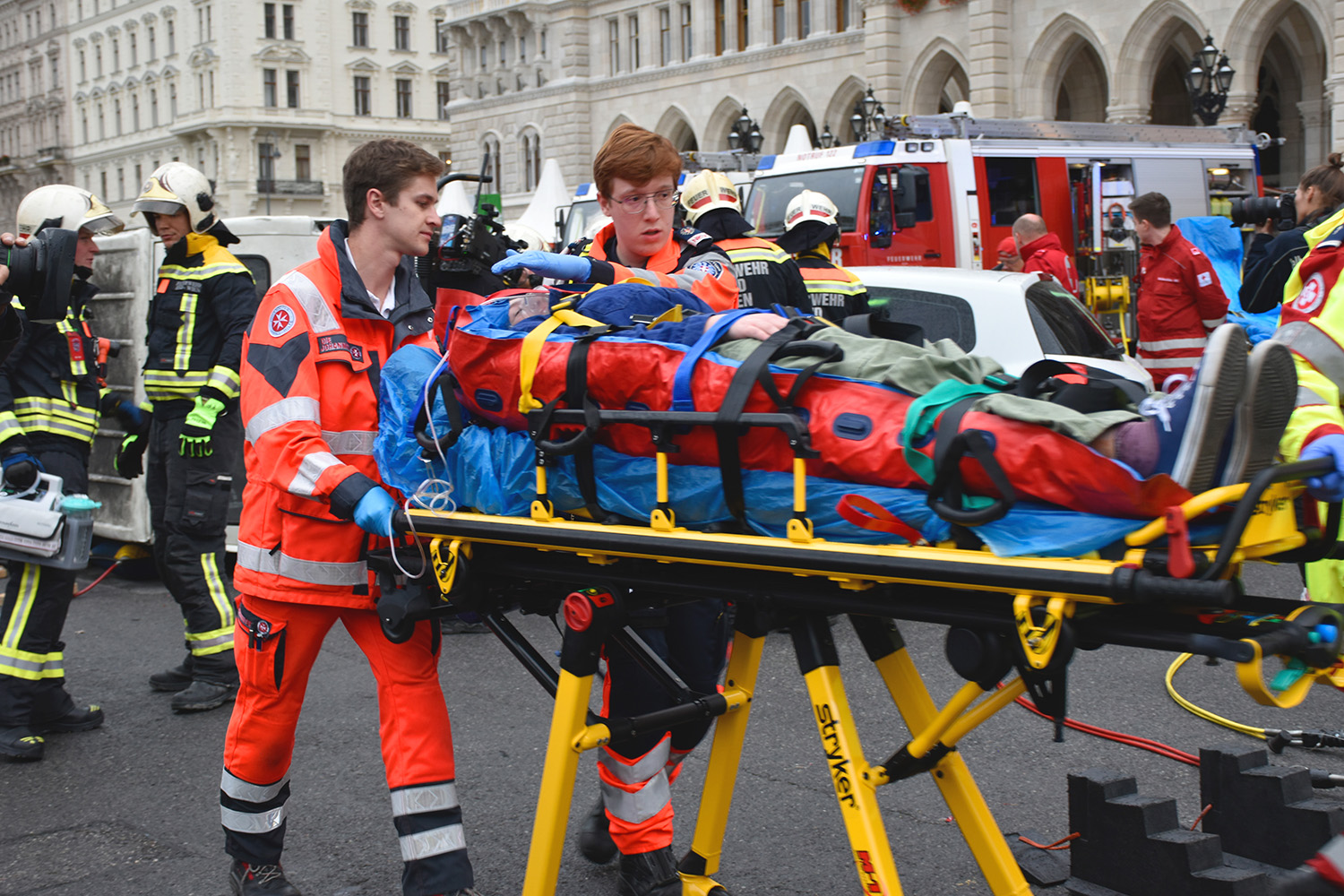 Ein Johanniter schiebt die Patientin auf der Bahre weg.